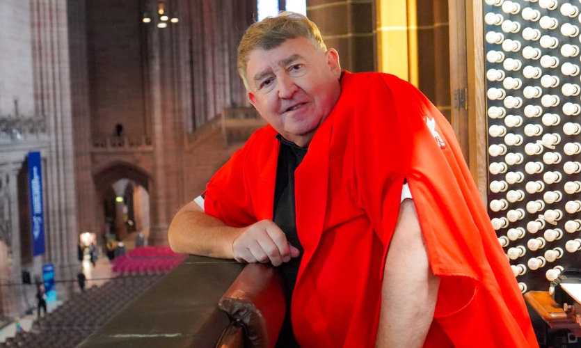 Ian dressed in a red gown sat at the organ in the cathedral